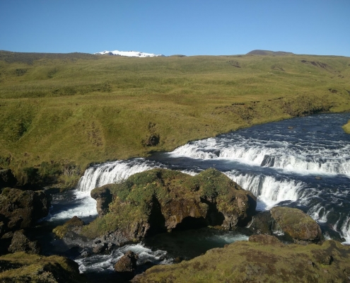 Día Internacional contra el Cambio Climático. Aparece un paisaje natural con un río y cascadas. Islandia